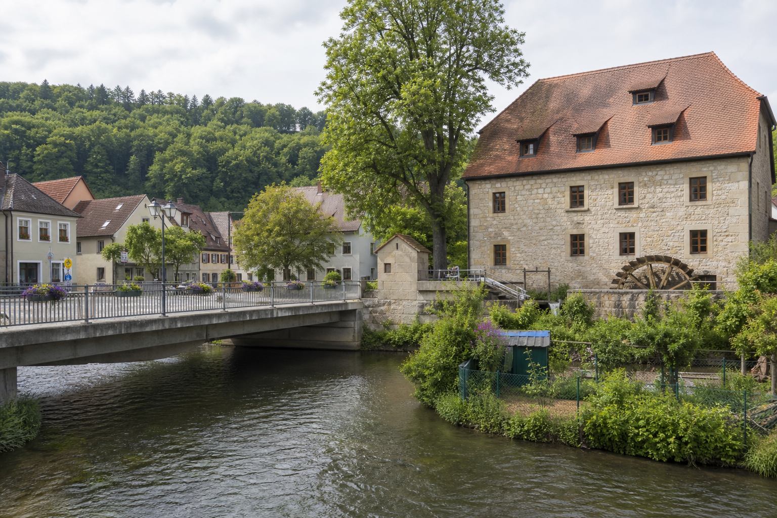 Kleiner fränkischer Ort mit Steinbrücke und Gärten